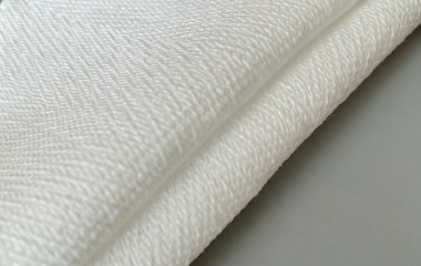 Herringbone pattern spunlace composite nonwoven cleaning material with high friction and durable wiping performance