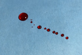 Medical tri-repellent spunlace nonwoven material for surgical gowns and drapes